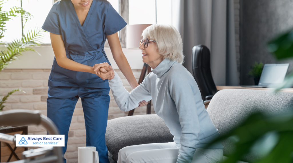 Senior getting help standing up by a caregiver.