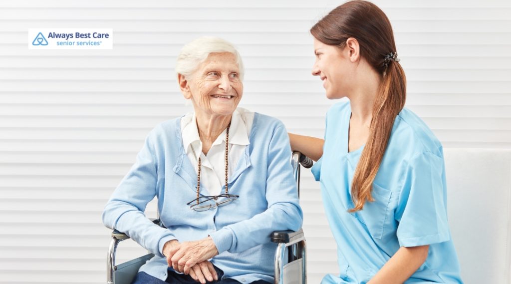 <strong>Kind Conversations: Bringing Up Hearing Loss with Someone You Love</strong> 5 Posts A senior woman sits in a wheelchair, smiling and interacting with a caregiver in a friendly and supportive environment.