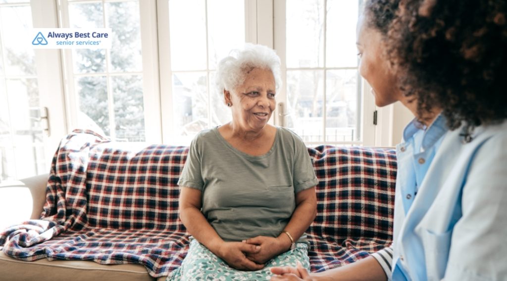 <strong>Kind Conversations: Bringing Up Hearing Loss with Someone You Love</strong> 4 Posts A senior woman is sitting on a couch with a caregiver, enjoying a conversation in a comfortable home setting.