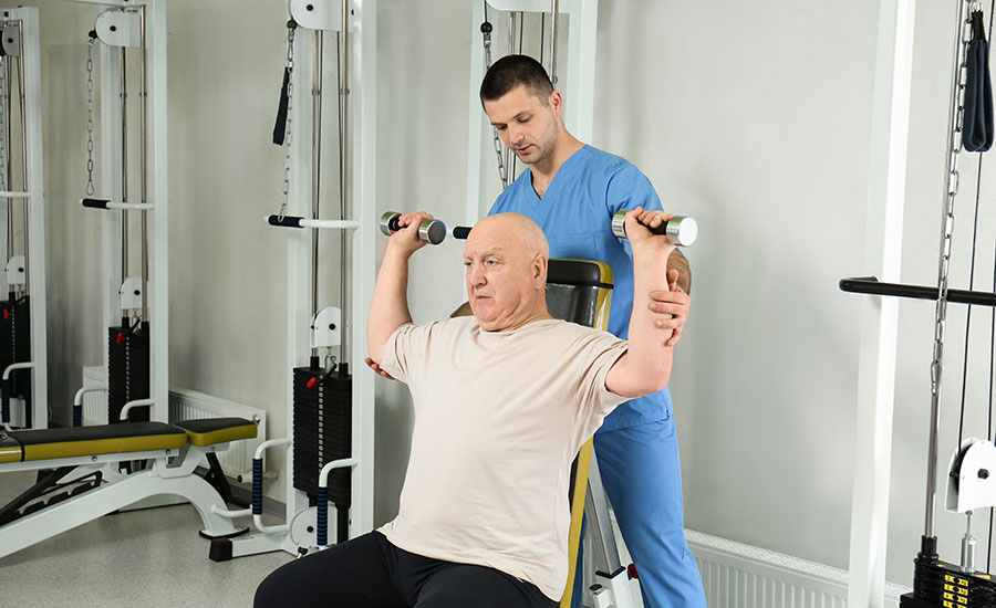 A caregiver helping a senior perform balance exercises​