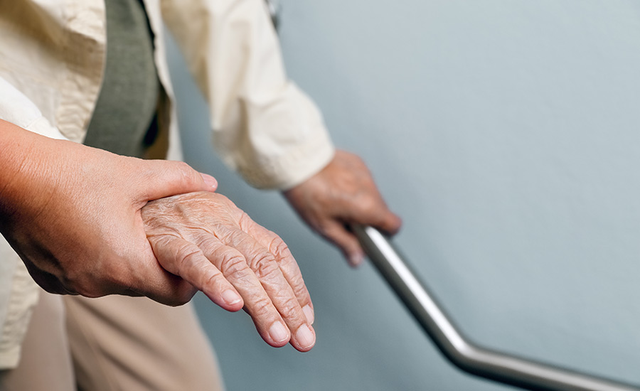 An elderly woman holding a handrail​